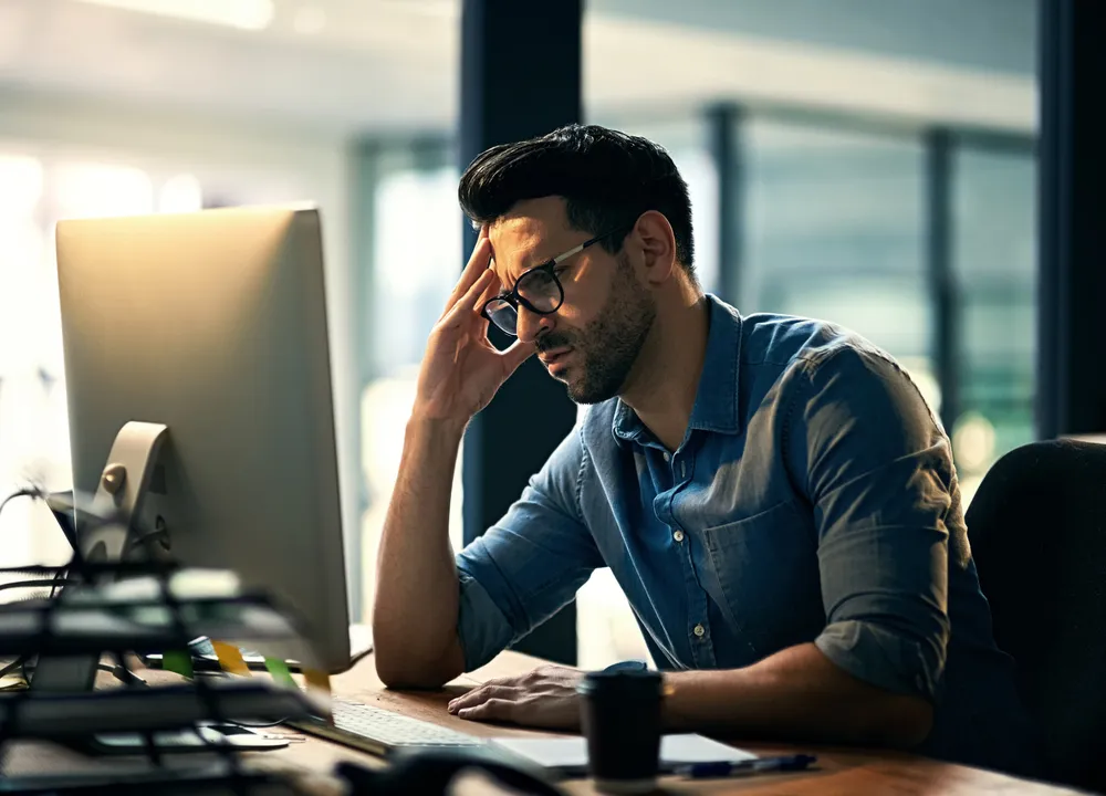 Frustrated business owner at his computer, wondering why his business is not showing up on Google's local map pack